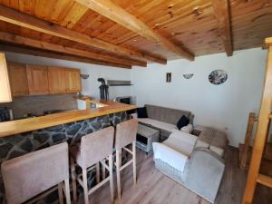 a kitchen and living room with a bar and chairs at Katun Mokra in Podgorica +18 photos