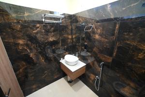 a bathroom with a toilet and a sink at Eloras Inn in Siliguri