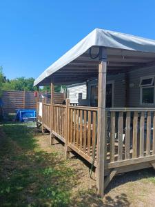 a wooden deck with a canopy on top of it at Emeraude aux 1000 Etangs in Belonchamp