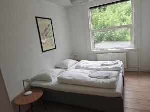 a bedroom with two beds and a window at Satellit lejligheder Vejle C in Vejle