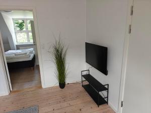 a living room with a flat screen tv on a wall at Satellit lejligheder Vejle C in Vejle