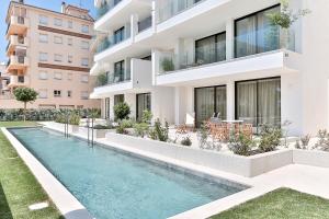 an exterior view of a building with a swimming pool at Hotel & Apartaments Thalassa Sport & Wellness in Roses