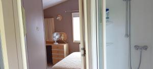 a bedroom with a shower and a bed and a dresser at Emeraude aux 1000 Etangs in Belonchamp