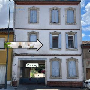 a building with an arrow pointing to a parking sign at Le Pastel Albigeois Parking & jardin 1km Unesco in Albi