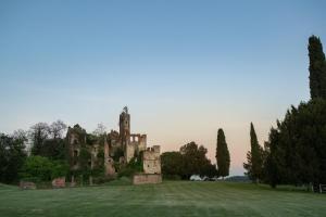 an old castle on top of a grass field at B&B Tenuta Castello Golf Club in Cerrione