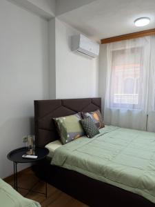 a bedroom with a bed and a table and a window at Eva apartment in Ohrid
