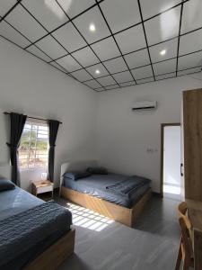 a bedroom with two beds and a window at Mian Motel in Vĩnh Hội