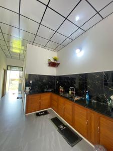a kitchen with black marble counter tops and wooden cabinets at Mian Motel in Vĩnh Hội +7 photos