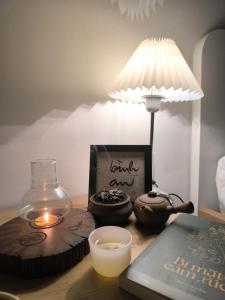 a table with a lamp and a book and a candle at Mian Motel in Vĩnh Hội