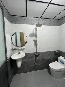 a bathroom with a sink and a toilet and a mirror at Mian Motel in Vĩnh Hội