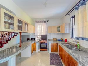 a kitchen with a sink and a stove top oven at Fiche Villas in Mombasa