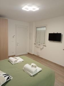 a white room with two white towels on a bed at Agriturismo al rosari in Aquiléia