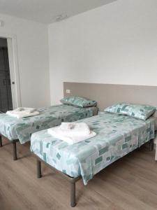 two beds sitting in a room with at Agriturismo al rosari in Aquiléia