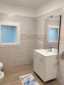 a bathroom with a sink and a toilet and a mirror at Agriturismo al rosari in Aquiléia