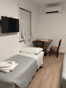 a bedroom with two beds and a table and a desk at Agriturismo al rosari in Aquiléia