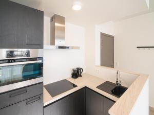 a kitchen with black and white cabinets and a sink at City Hideaway with Terrace in Antwerp in Antwerp