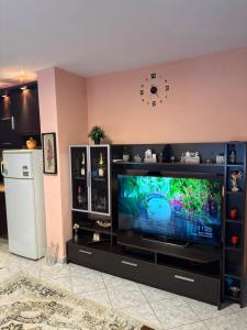 a living room with a television and a clock on the wall at Flat in Leskovik in Leskovik +6 photos