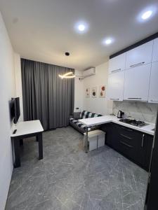 a kitchen with white cabinets and a couch in a room at Panorama in Sumqayıt