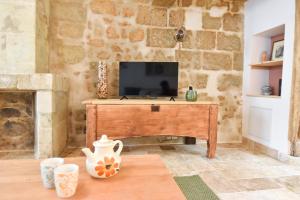 a living room with a television on a wooden table at Chez Marcel et Louise in Chinon