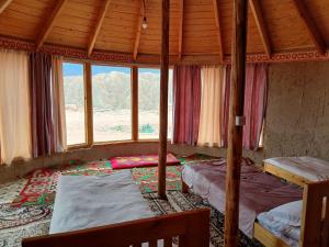 a bedroom with two beds in a room with windows at Asman Tör Yurt Camp in Tong