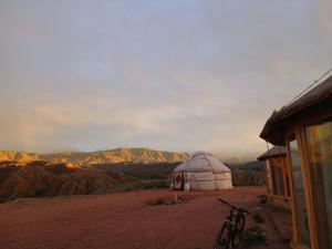 a bike parked next to a yurt in the desert at Asman Tör Yurt Camp in Tong