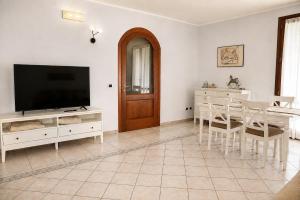 a living room with a television and a table with chairs at Villa Porpora Luxury Design in Modena +32 photos