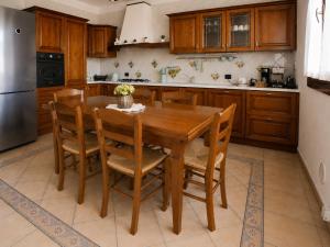 a kitchen with a wooden table and wooden cabinets at Villa Porpora Luxury Design in Modena