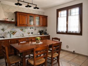 a kitchen with a wooden table and wooden cabinets at Villa Porpora Luxury Design in Modena