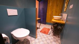 a bathroom with a toilet and a sink at Le Gîte des Jardins d'Ispahan in Prignac-et-Marcamps