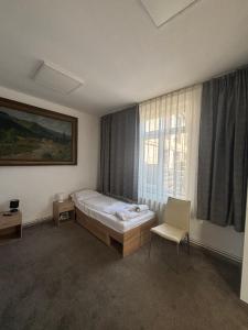 a bedroom with a bed and a window and a chair at Twin-Tam House in Timişoara