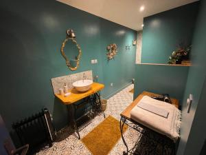 a bathroom with a sink in the corner of a room at Le Gîte des Jardins d'Ispahan in Prignac-et-Marcamps