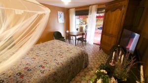 a bedroom with a bed with a canopy at Le Gîte des Jardins d'Ispahan in Prignac-et-Marcamps