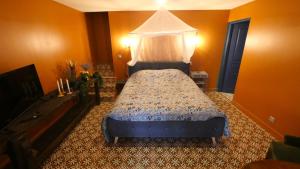 a bedroom with a bed with a canopy at Le Gîte des Jardins d'Ispahan in Prignac-et-Marcamps +32 photos