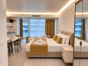 a bedroom with a large bed and a dining room at WHITE TITANIC LUXURY Sea View & Studios in Mamaia Sat/Năvodari