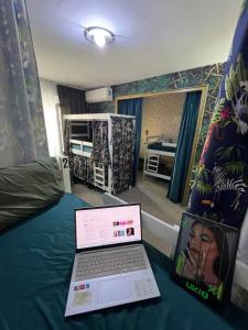 a laptop computer sitting on a bed in a bedroom at Amazon Hostel Center Podgorica in Podgorica