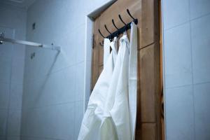 a rack of white towels hanging in a bathroom at Tales Luxury in Kampala +12 photos