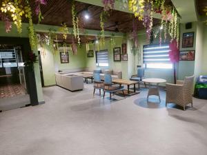 a waiting room with tables and chairs and flowers at Classic Hotel in Pānīpat