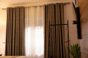 a bedroom with a window with curtains at Tales Luxury in Kampala