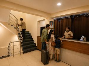 a group of people standing at a counter with luggage at Nathan's Residency in Tiruchirappalli