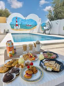 a table topped with plates of food next to a pool at Djerba Moon in Djerba