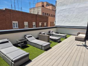 a rooftop patio with couches and grass on a building at Hotel General Ricardos in Madrid +37 photos