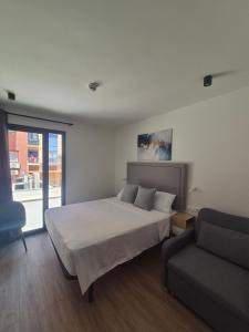 a bedroom with a bed and a couch at Hotel General Ricardos in Madrid