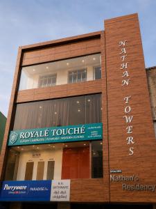 a building with a sign on the side of it at Nathan's Residency in Tiruchirappalli