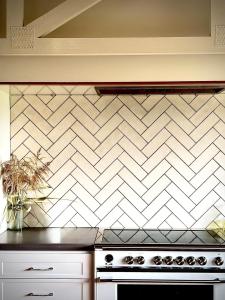 a kitchen with a stove and a white tiled wall at Bunnugal House in Dunkeld +29 photos
