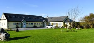 a white car parked in front of a house at O'Connor's Accommodation in Doolin