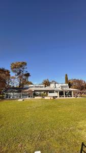 a large building with a grass field in front of it at Bunnugal House in Dunkeld