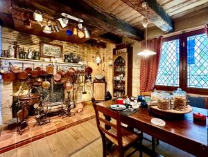 a room with a wooden table and a kitchen with pots and pans at Le Colombier de Cyrano et Roxane in Bergerac