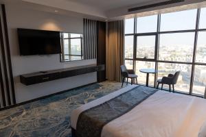 a hotel room with a bed and a flat screen tv at فندق ديماس DEMAS Hotel in Khamis Mushayt