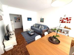 a living room with a table and a couch at Estoril 2 bd by the Beach in Estoril