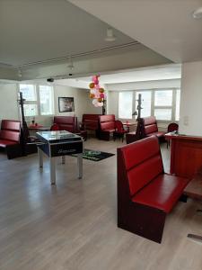 a waiting room with red chairs and a table at Kattohuoneisto antinkatu in Pori